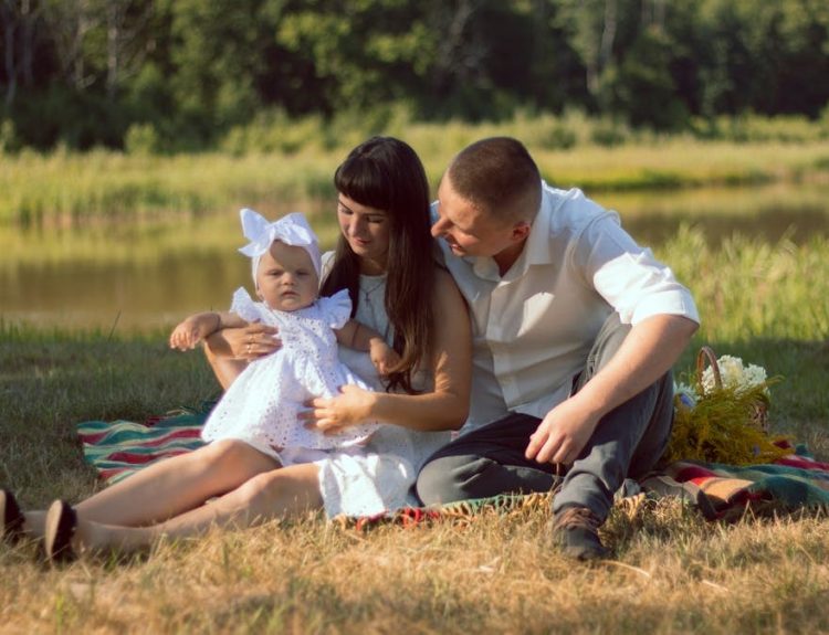 A happy family enjoys a summer picnic by a scenic lake.