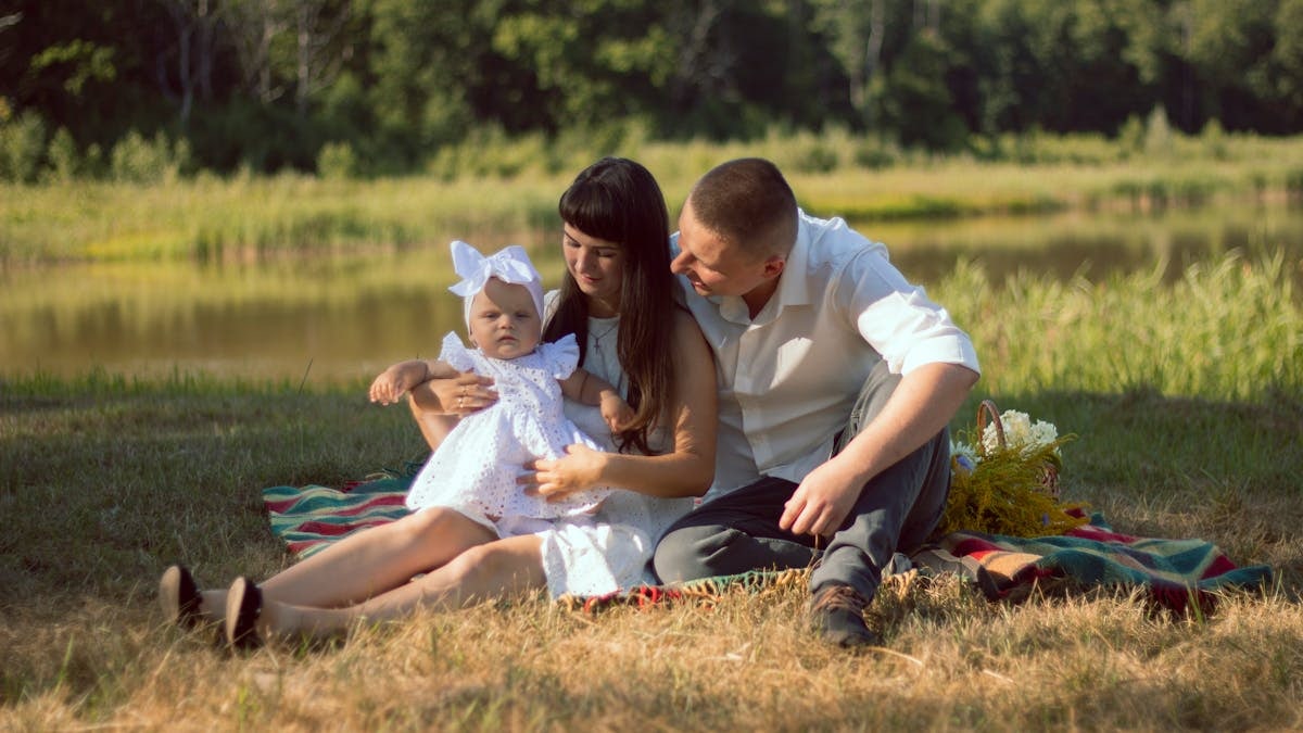 A happy family enjoys a summer picnic by a scenic lake.