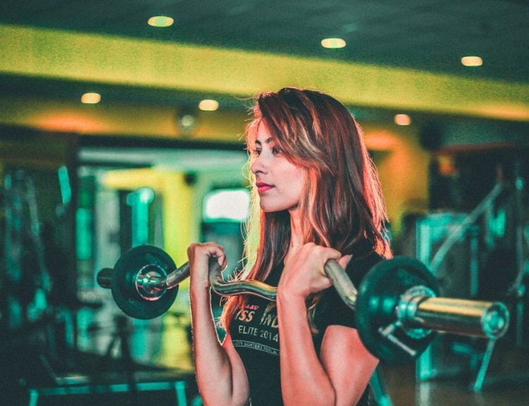 woman lifting black and gray barbell